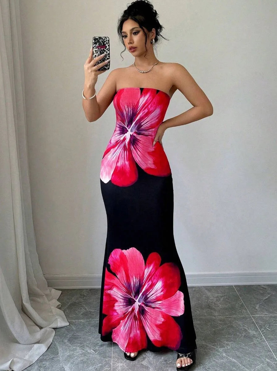 Woman in pink floral strapless maxi dress with black base and bold oversized blossom print