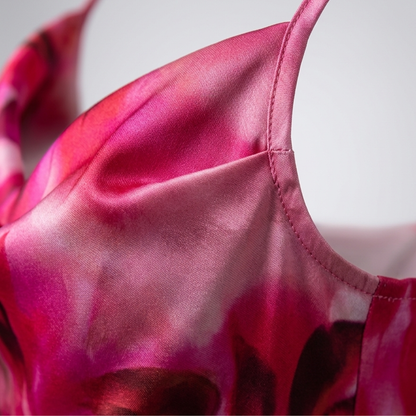 Close-up of pink floral satin fabric on a women's summer dress with thin strap