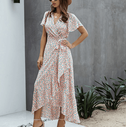 Pink floral wrap midi dress with V neck, flutter sleeves, and side tie detail