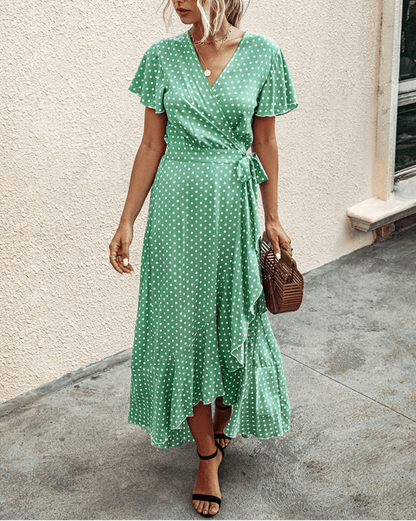 Green polka dot wrap midi dress with V neck, flutter sleeves, and ruffled high-low hem