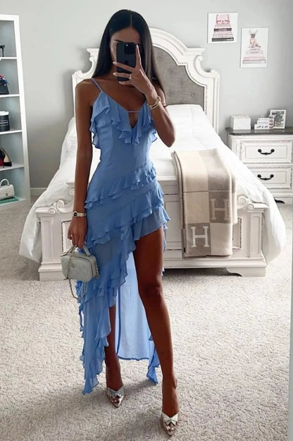 Model shot of a light blue ruffled spaghetti strap midi dress styled with heels and handbag