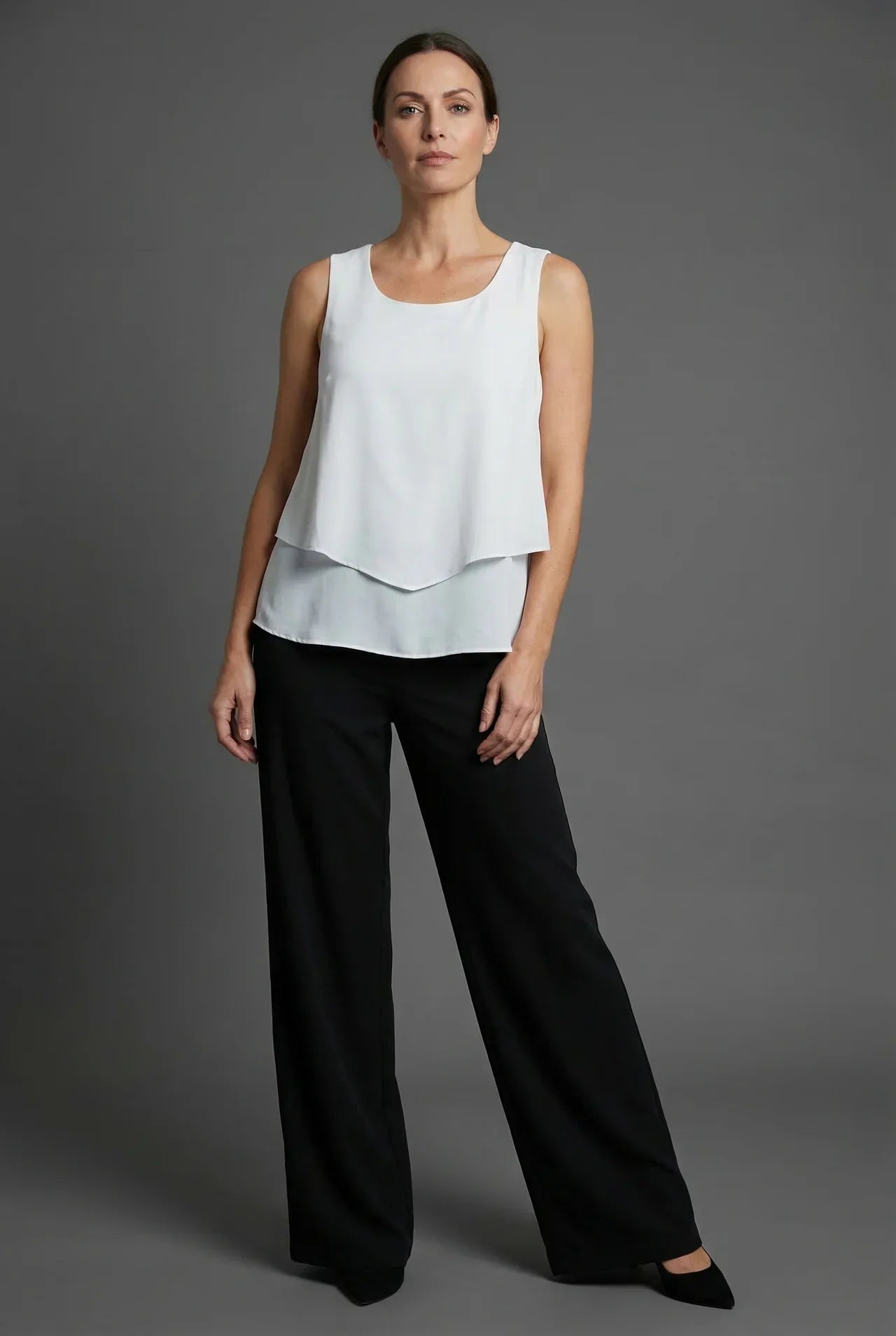 White sleeveless layered top with black wide leg pants in a minimalist summer co ord set