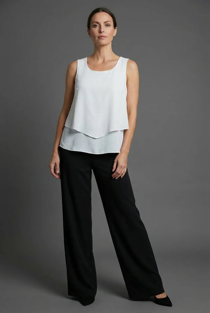 White sleeveless layered top with black wide leg pants in a minimalist summer co ord set