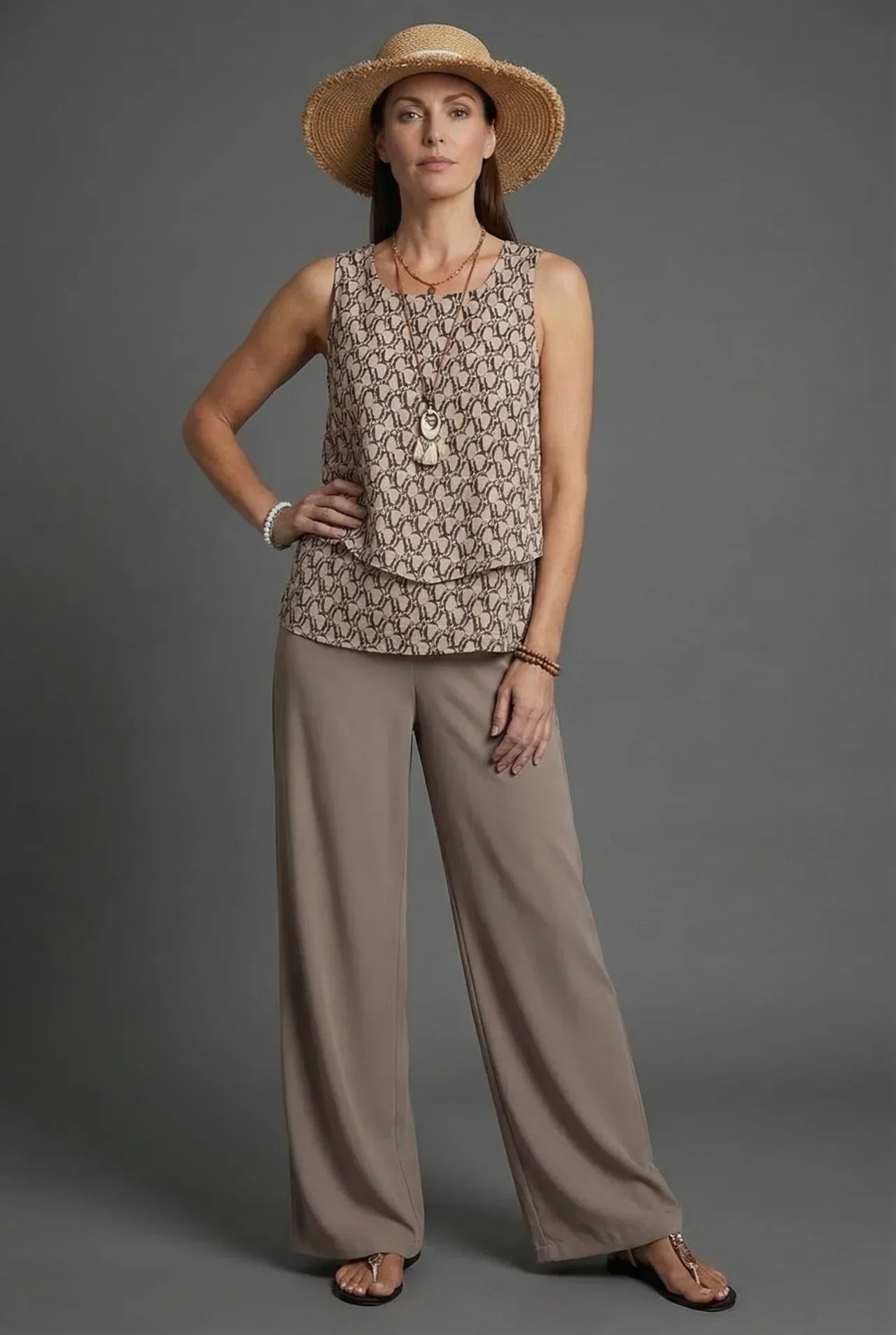 Beige sleeveless patterned top with loose wide leg linen pants and straw hat co ord set