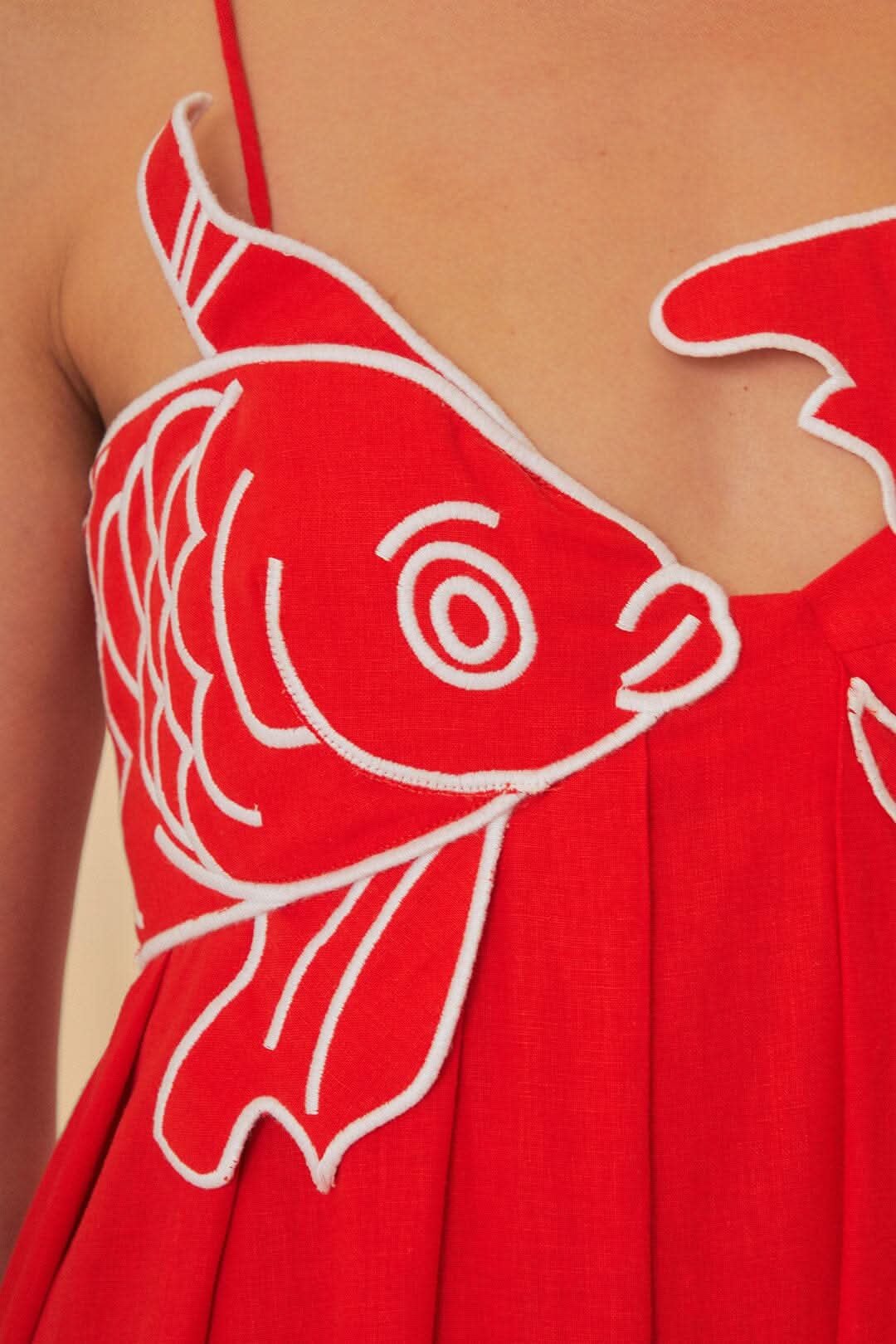 Close-up of red fish print maxi dress bodice with bold fish graphic and V neckline