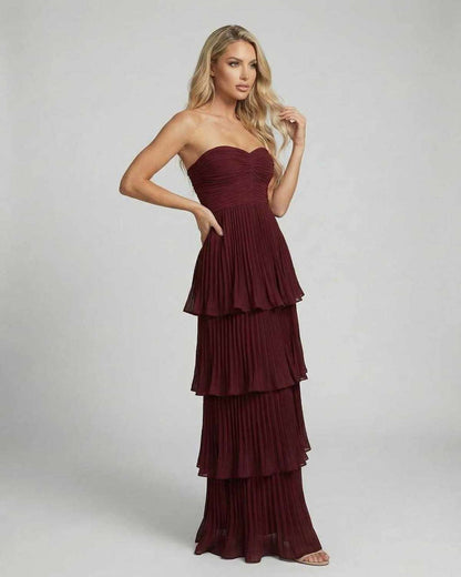 Angled view of burgundy strapless wedding guest maxi dress with tiered chiffon layers
