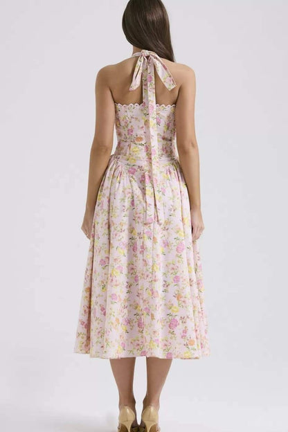 Back view of floral halter midi dress with tie neck, smocked back, and flowing skirt