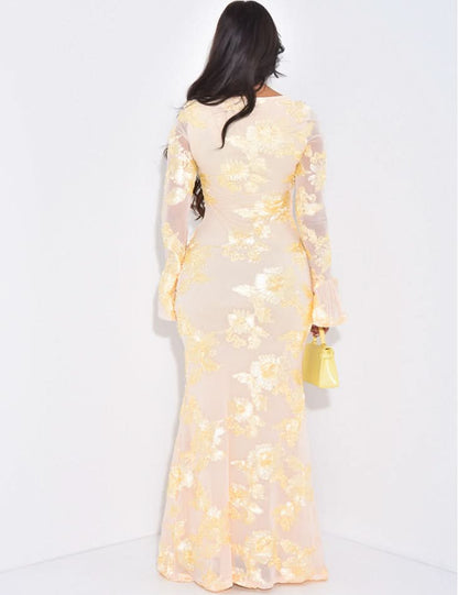 Back view of cream floral long sleeve maxi dress with sheer sleeves and floor-length hem