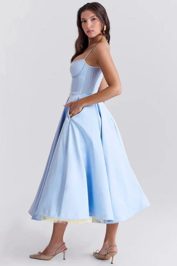 Light blue midi dress with spaghetti straps, fitted bodice, and full wedding guest skirt