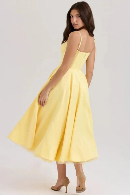 Back view of yellow midi dress showing fitted waist, open back, and voluminous skirt