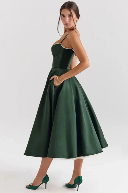 Back angled view of dark green midi wedding guest dress with open back and full skirt