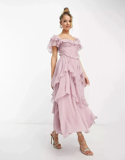 Front view of blush pink wedding guest ruffle midi dress with square neckline and tiered chiffon skirt