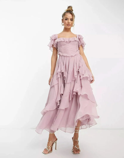 Blush pink ruffle midi dress with off-shoulder sleeves and flowing layered skirt, wedding guest dress