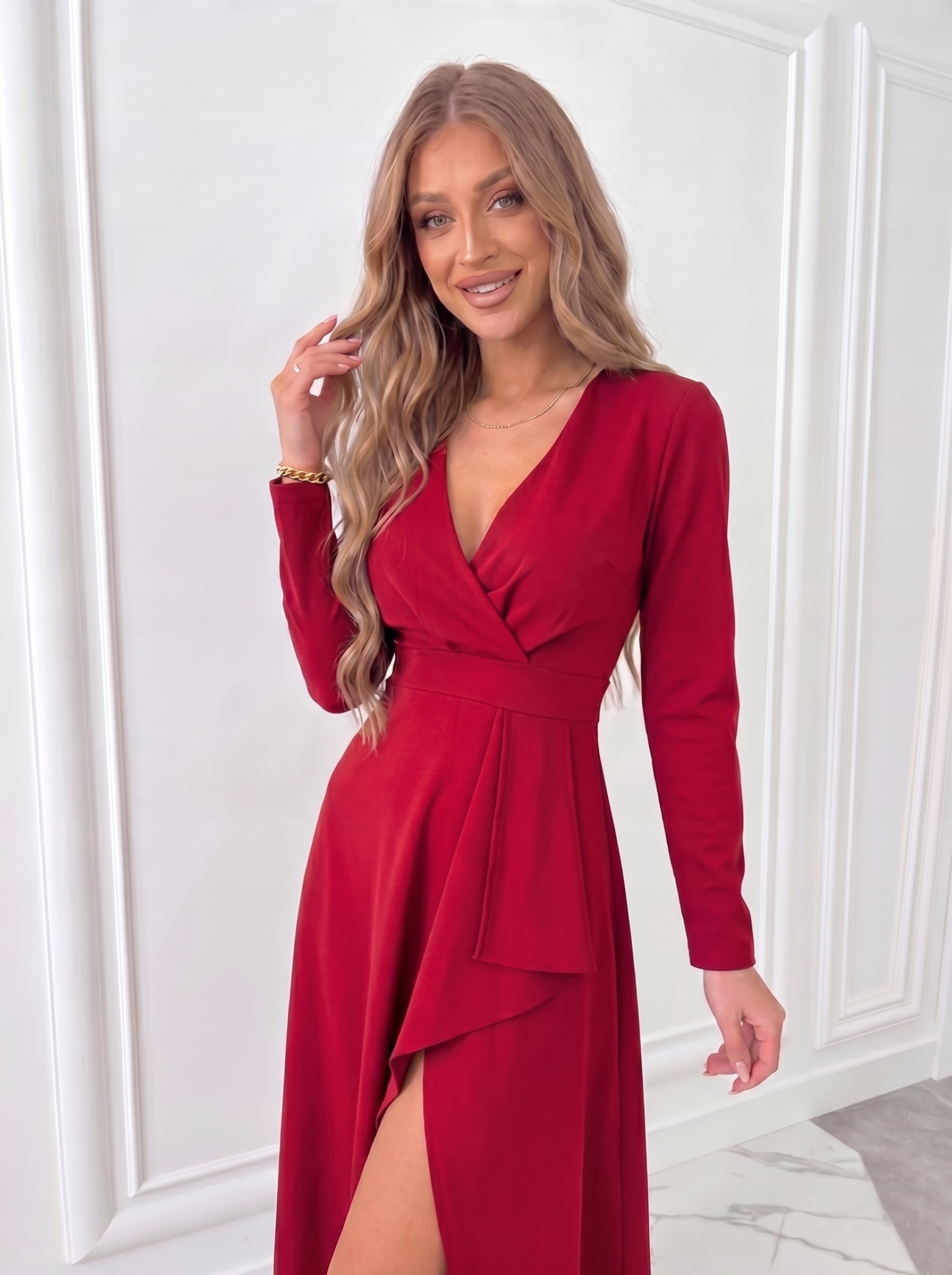Close-up of red women's wrap midi dress showing fitted waist, long sleeves and soft draped neckline